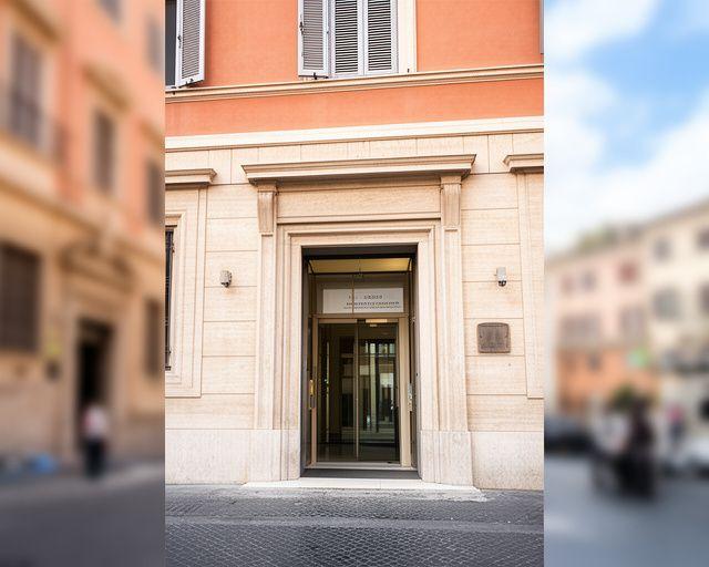 Ingresso elegante di uno studio legale a Roma con luce naturale e indicazioni urbane del quartiere